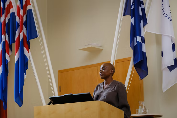 A woman addressing others on a stage