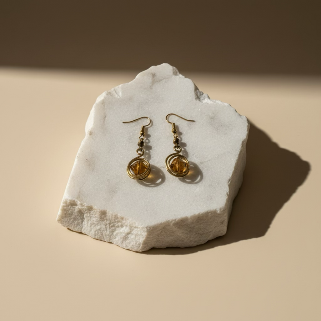 Drop earrings featuring wire-wrapped round glass stones and geometric detailing in yellow brass.