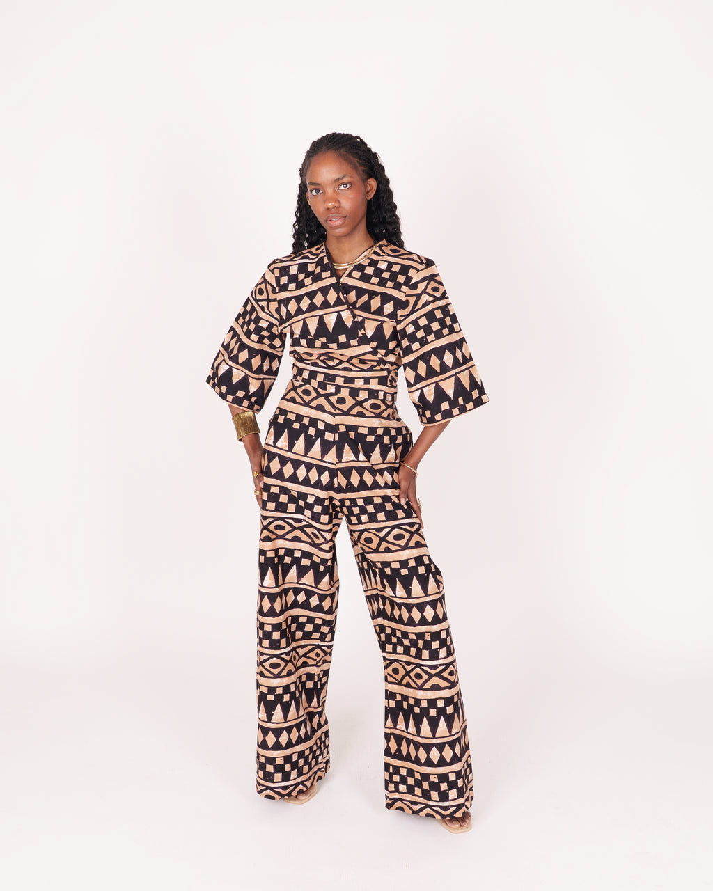 A relaxed fit suit featuring wide sleeves, a banded waist, and ankle-length wide leg pants, adorned with subtle geometric motifs.