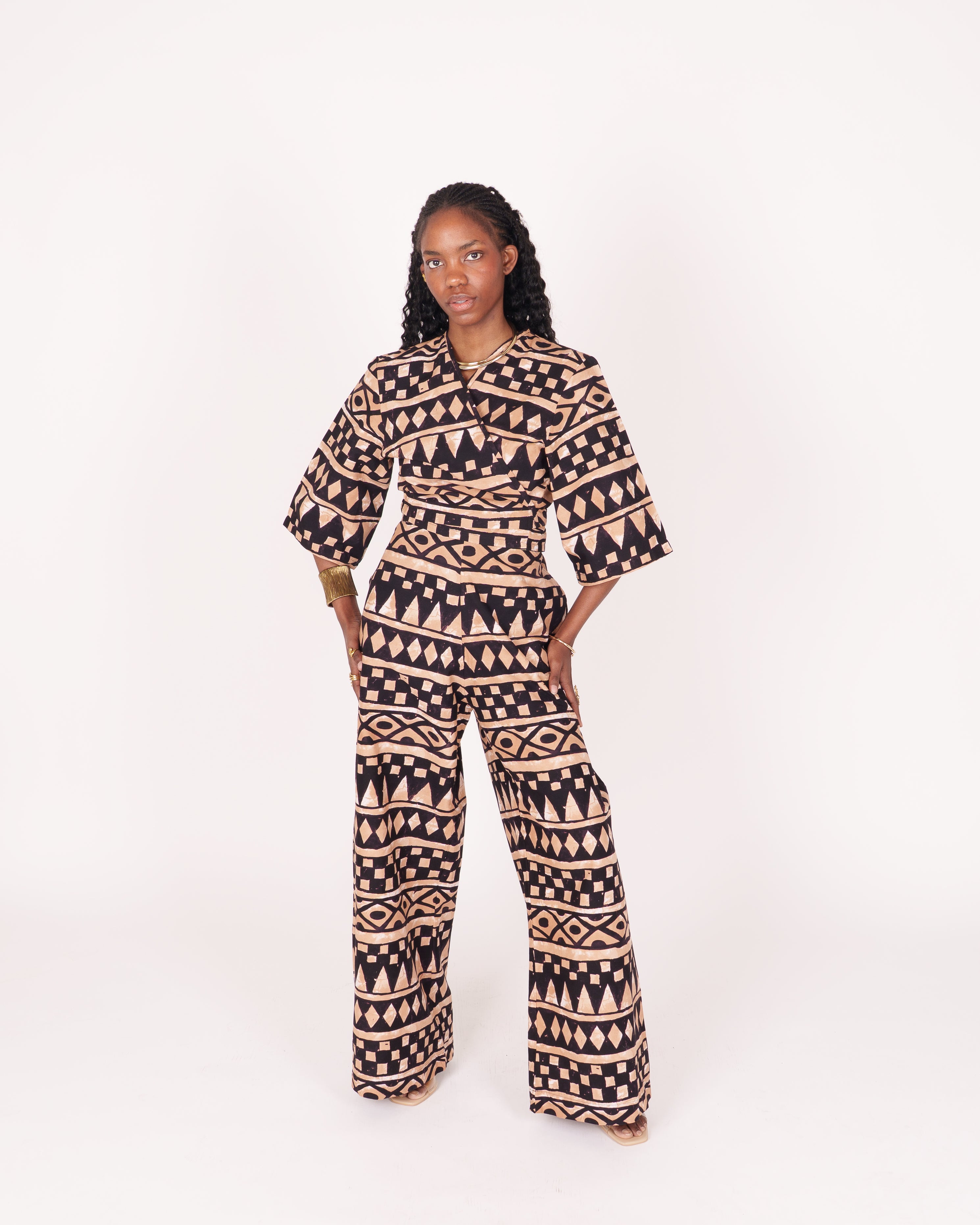 A relaxed fit suit featuring wide sleeves, a banded waist, and ankle-length wide leg pants, adorned with subtle geometric motifs.