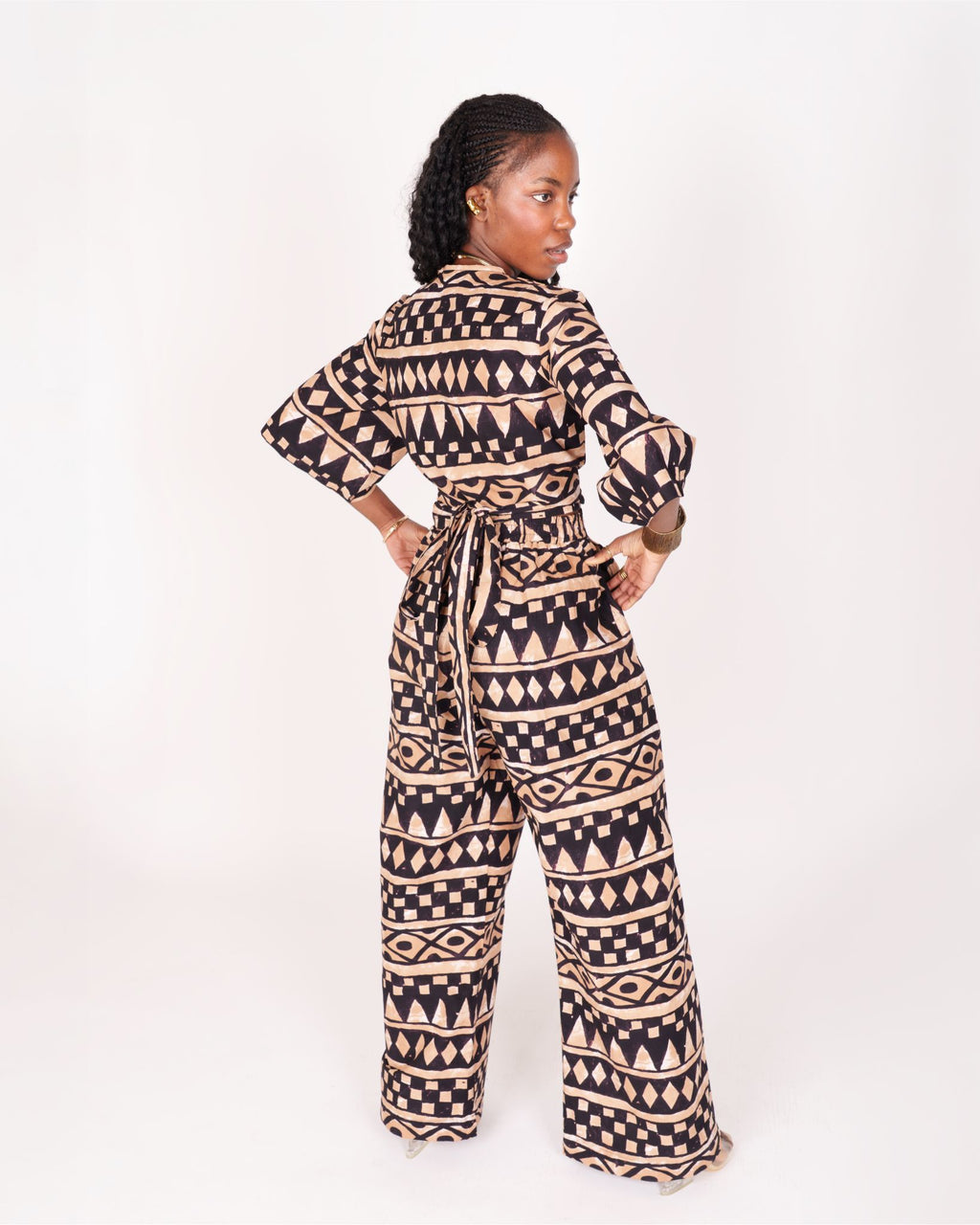 A relaxed fit suit featuring wide sleeves, a banded waist, and ankle-length wide leg pants, adorned with subtle geometric motifs.