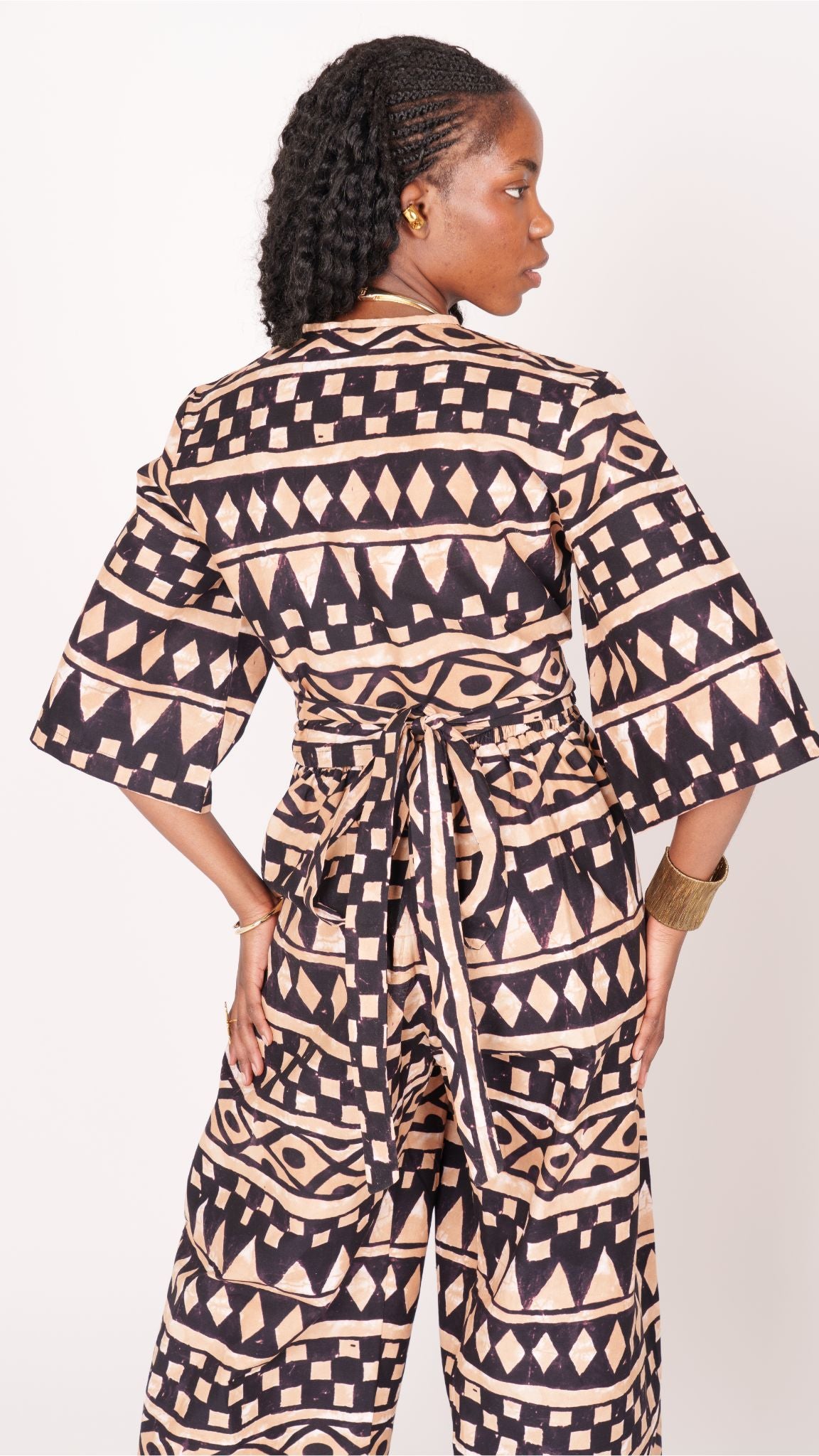 A relaxed fit suit featuring wide sleeves, a banded waist, and ankle-length wide leg pants, adorned with subtle geometric motifs.