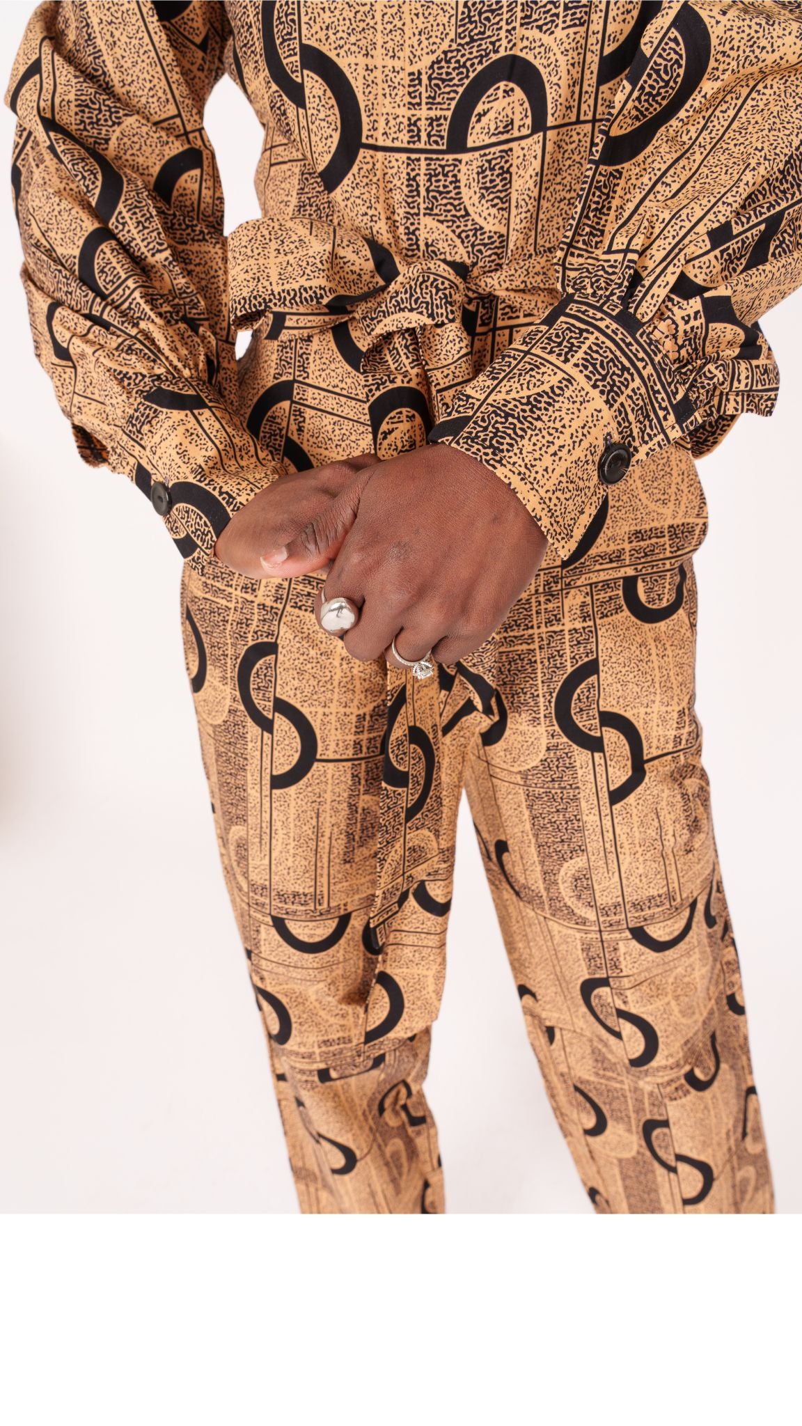 Jumpsuit featuring long balloon sleeves, a fitted waist with a detachable belt, and straight ankle-length pants adorned with an abstract pattern.